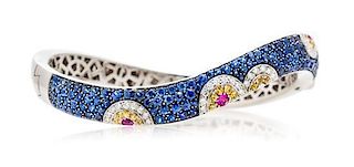 * An 18 Karat White Gold, Multicolor Sapphire and Diamond Bangle Bracelet, Cellini, 28.40 dwts.