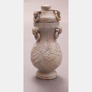 A Chinese Archaistic Style Carved Calcified Jade Vase and Cover on a Carved Hardwood Stand.