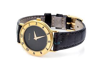 * A Gucci Goldtone Wristwatch, 7" x 1".
