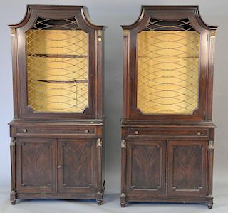 Pair of mahogany cabinet, each in two parts with grillwork doors, three glass shelves, and metal heads and feet. ht. 78 in.; wd. 37 ...