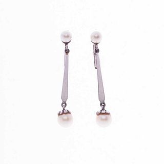 Par de aretes con perlas en plata paladio. 4 perlas cultivadas color blanco de 4 y 6 mm. Peso: 3.8 g.