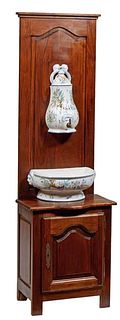 French Provincial Faience Lavabo, 20th c., with a covered floral decorated reservoir and lower bowl, on a bowed oak support with a lower fielded panel