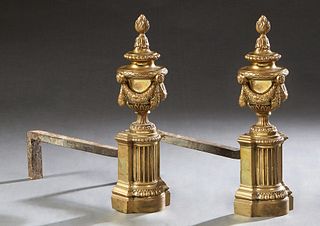 Pair of French Neo Classical Gilt Bronze and Iron Chenets, 19th c., with flame topped garland draped urns on reeded columnar supports, on stepped reli