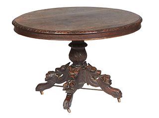French Carved Oak Henri II Style Dining Table, c. 1880, the oval carved edge top, over a wide skirt, on a turned urn support, to fox and nut carved sp