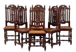 Set of Six French Henri II Style Carved Oak Dining Chairs, c. 1880, the canted back with a leaf carved crest flanked by finials, above a leaf carved s