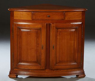 French Louis Philippe Style Carved Walnut Corner Cabinet, 20th c., the bowed rounded edge top over a center frieze drawer and double fielded panel con