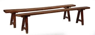 Pair of French Provincial Carved Cherry Benches, early 20th c., the rectangular planks on two splayed trestle form supports joined by rectangular stre