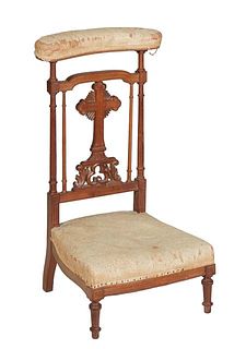 French Carved Walnut Prie Dieu, 19th c., the curved cushioned armrest over a cruciform back splat, above a trapezoidal bowed cushioned kneeler on turn