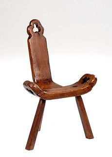 Spanish Provincial Carved Oak Hall Chair, 20th c., the canted single plank back over a curved seat, both with trefoil cutouts, on tripodal square legs