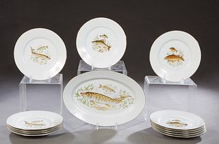 French Thirteen Piece Limoges Porcelain Fish Set, 20th c., with 12 circular plates and an oval platter, with gilt rims and transfer fish decoration, P