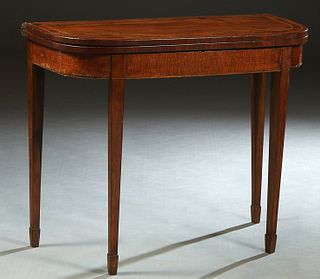 English Inlaid Mahogany Demilune Games Table, early 20th c., the swiveling top opening to a baize lined gaming surface, over game storage on tapered s