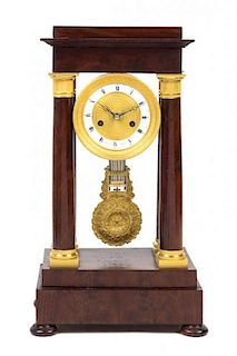 An Empire Gilt Metal Mounted Mahogany Portico Clock Height 18 5/8 inches.