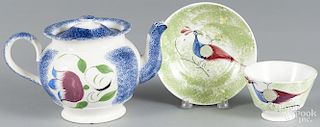 Blue spatter teapot with tulip, 5 1/4'' h., together with a green peafowl cup and saucer.