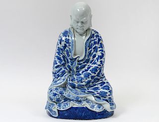 BLUE AND WHITE PORCELAIN FIGURE OF A PRAYING MONK