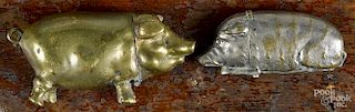 Two figural pig match vesta safes, ca. 1900, to include a brass example, 2 5/8'' l.