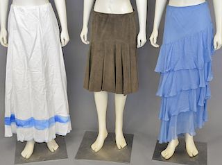 Four Ralph Lauren purple label skirts, blue silk crepe, pink silk organza, white linen and dark stone suede (size 4).