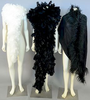 Six feather boas including hot pink, black, and white along with a silk and feather scarf.