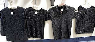 Five black sequined or beaded women shirts.