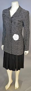 Chanel two piece suit including black and white striped long jacket with flower accent and a black pleated skirt.