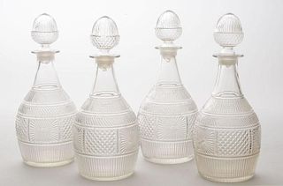 SET OF FOUR MOLDED GLASS DECANTERS AND STOPPERS