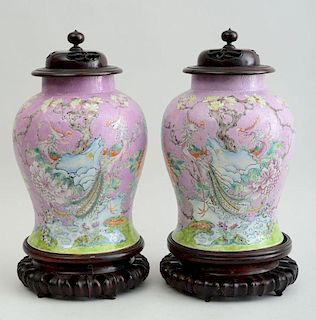 PAIR OF INCISED PINK-GROUND FAMILLE ROSE PORCELAIN JARS WITH HARDWOOD COVERS AND STANDS