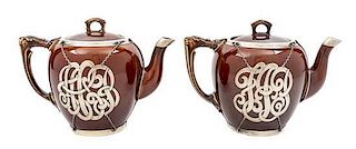 * A Pair of Ceramic Silver Overlay Teapots Height of taller 6 inches.