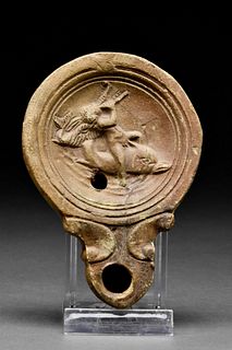 ROMAN TERRACOTTA OIL LAMP WITH EROS RIDING ON A DOLPHIN