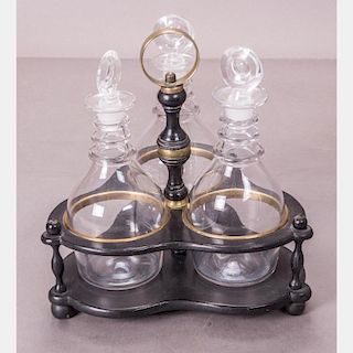 A Regency Style Ebonized Wood and Brass Three Bottle Decanter Stand with Glass Blown Decanters, 19th Century.