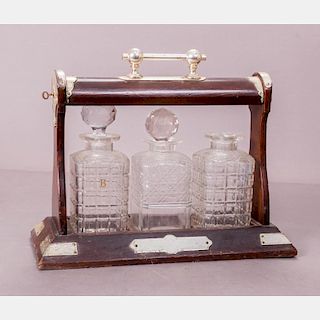 A Regency Style Brass and Mahogany Tantalus with Three Cut Glass Decanters, 19th/20th Century.