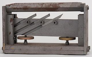 Dice Edger. American, ca. 1960. Heavy steel tool for manufacturing crooked whip-type dice. A set of three adjustable blades rests underneath the upper