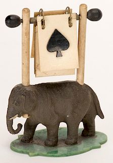Elephant Trump Indicator. Circa 1930. Elephant stands on celluloid base. Both sides of celluloid markers have suit symbols. Excellent.