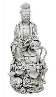 A BLANC-DE-CHINE GUANYIN SEATED ON A ROCK WITH A DEER AND A CRANE