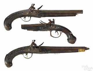 Three North African flintlock pistols, to include two single barrels with wire inlaid stocks