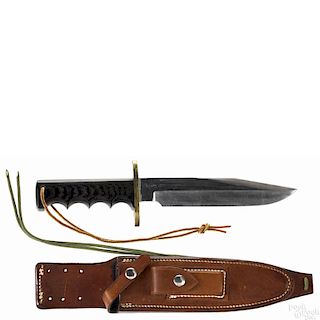 Randall made Bowie knife in a sheath with a brass crossguard, a wooden grip