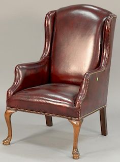 Leather upholstered Queen Anne style wing chair.