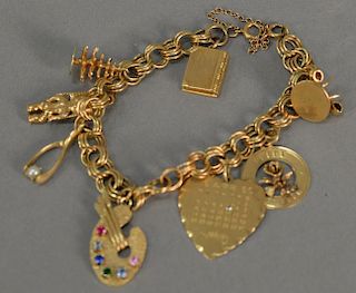 14K gold charm bracelet with 7 charms, 29.7 grams.
