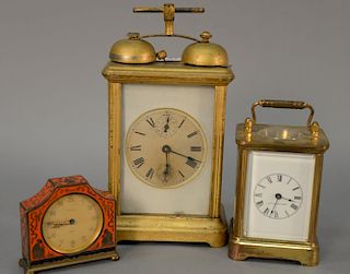 Three desk or alarm clocks to include Kienzle Day enameled clock, a brass and glass carriage clock with enameled dial, and a carriag...