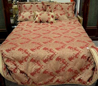 King size red and gold bedspread with six pillows.