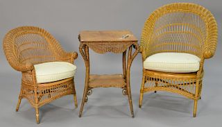 Three piece lot to include two wicker armchairs with rolled arms including a ladies chair and a gents chair in natural color with cu...