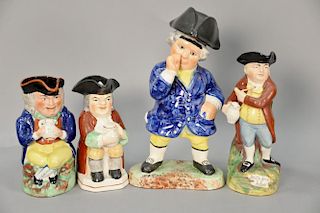 Four Staffordshire Toby figures including Hearty Good Fellow standing jug, two holding a pitcher, and a standing figure with a cover...
