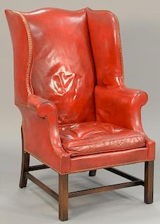Red leather upholstered wing chair with brass button borders (wear).