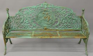 Large iron outdoor garden bench with round cemter medallion of woman surrouned by a branch and bird motif.
