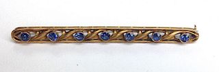 14k y.g. bar pin having 7 round cut bezel set sapphires each approx. 3mm in diameter. 2¾"l.