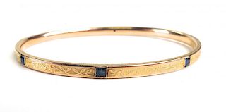 14k y.g. bangle having 3 small square cut sapphires and fine foliage decoration. 11.8g. 2¾" diameter