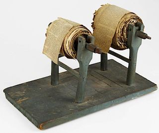early 19th c double paper roller in old green paint, retaining early printed material stitched toget