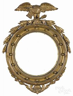 Gilt convex mirror, early 20th c., with an eagle finial, 35 1/2'' h.