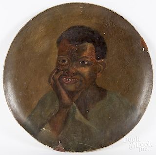 Large painted pâpiér-mache charger with a portrait of an African American boy, 21 3/4'' dia.