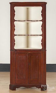 Painted pine two-part corner cupboard, 19th c., retaining an old red surface, 85'' h., 35 1/2'' w.