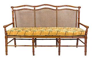 A Faux Bamboo and Caned Settee Height 40 x width 67 x depth 19 inches.