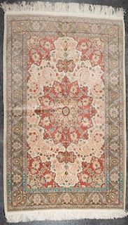 A Persian Wool and Silk Rug 5 feet 10 inches x 3 feet 10 inches.